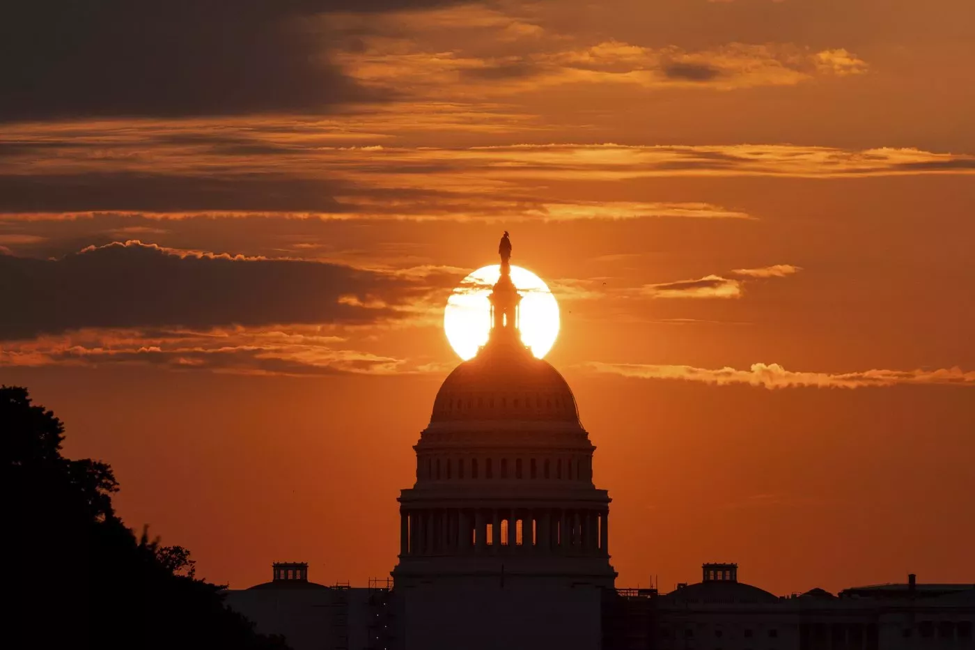 Dark orange sunrise behind the Capitol building.