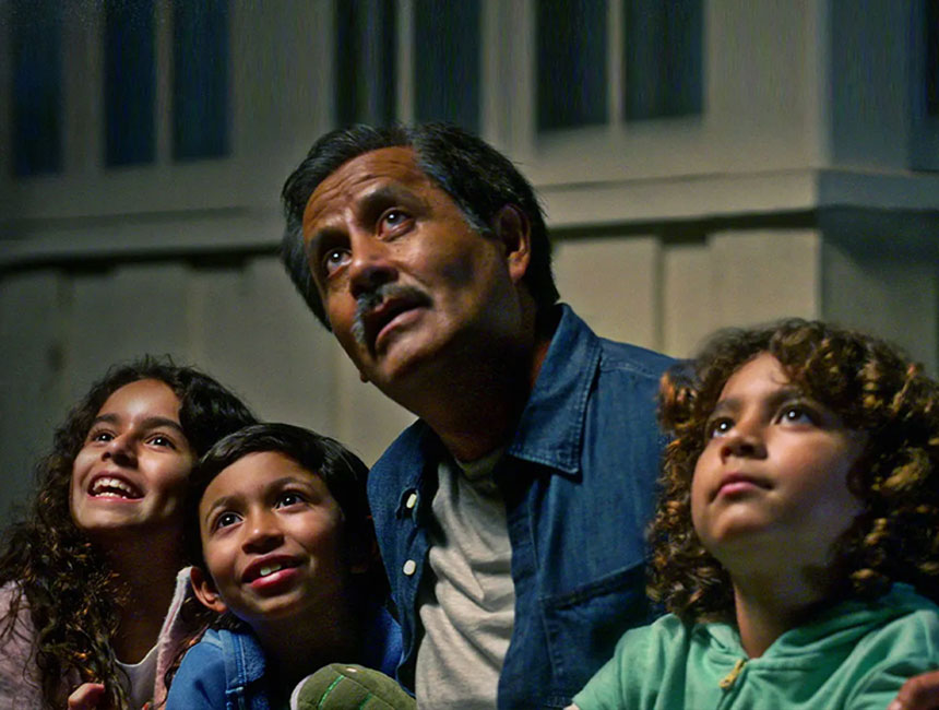 Man and three kids looking up and out, as if watching a telenovela.