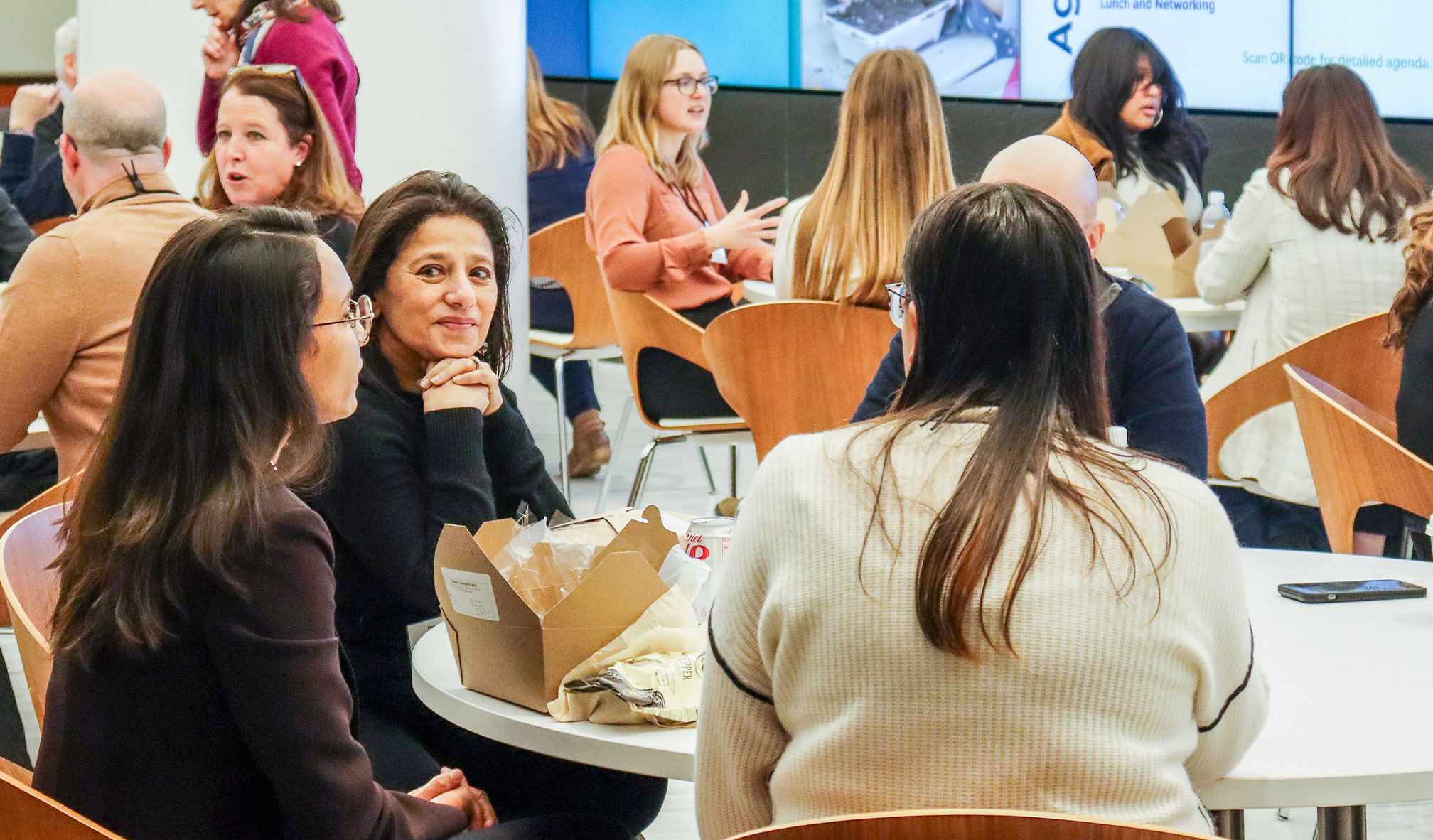 Groups of people gathered around tables, engaging in dialogue.