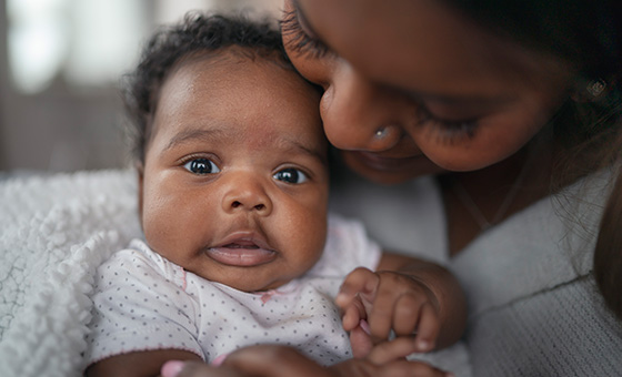 Mother holding her baby close, symbolizing a focus on child safety.
