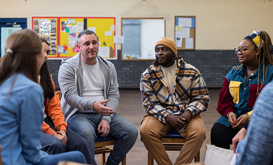 Group of people seated in a circle, participating in a group counseling session.