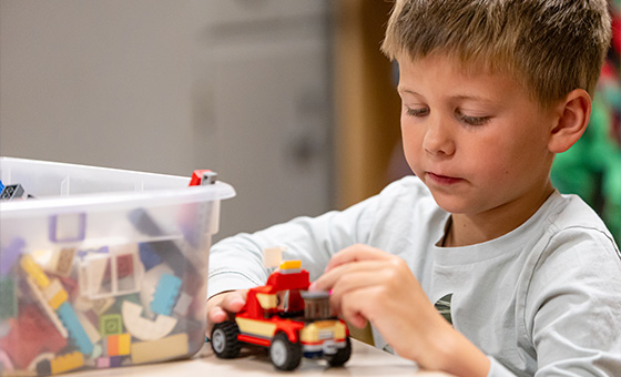 Child playing with Lego bricks depicting Early Childhood Learning and Development