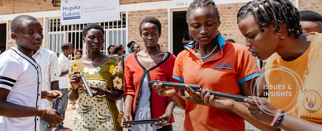 A photo of youths in Rwanda examining metal pipes