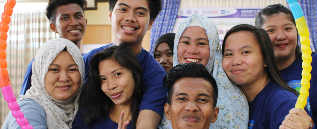 A photo of smiling youth in the Philippines holding a circle frame